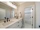 Bathroom featuring double sinks, white cabinets, granite countertops, and framed mirror at 625 Glenwood Se Pl, Atlanta, GA 30316