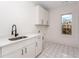 Bright laundry room with white cabinets, modern sink, and patterned tile floor at 1103 Boulevard Se Dr, Atlanta, GA 30317