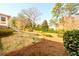 Landscaped backyard with mature trees, grass, and tiered garden beds at 1654 Deerfield Cir, Decatur, GA 30033