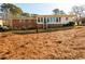 Back exterior view of a brick home, featuring a large yard, patio, and ample natural light at 1654 Deerfield Cir, Decatur, GA 30033