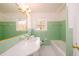 Charming bathroom with green tile, white countertops, and a well-lit vanity mirror at 1654 Deerfield Cir, Decatur, GA 30033