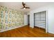 Stylish bedroom featuring hardwood floors, ceiling fan, and unique cactus-themed wallpaper at 1654 Deerfield Cir, Decatur, GA 30033