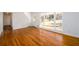 Sunlit living room with hardwood floors, a large window, and a doorway leading to other rooms at 1654 Deerfield Cir, Decatur, GA 30033