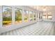 Light filled sunroom with views of the backyard through multiple windows and patterned tile flooring at 1654 Deerfield Cir, Decatur, GA 30033