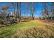 Large backyard featuring a well-kept lawn, mature trees, and a gazebo at 700 Hill Meadow Dr, Dacula, GA 30019