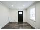 Neat living room boasts neutral paint, a window, and dark vinyl-plank flooring at 700 Hill Meadow Dr, Dacula, GA 30019