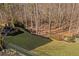 Serene backyard with manicured lawn, black metal fence, and wooded backdrop for privacy and enjoyment at 718 Park Haven Ln, Canton, GA 30115