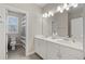 Bright bathroom featuring double vanity, large mirror and shower-tub combo with gray and white shower curtain at 718 Park Haven Ln, Canton, GA 30115