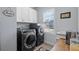 Laundry room with gray washer and dryer units, white cabinets, and stainless steel sink at 718 Park Haven Ln, Canton, GA 30115