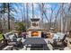 Stone outdoor fireplace and seating area with manicured flower beds for an inviting outdoor experience at 718 Park Haven Ln, Canton, GA 30115