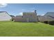 A spacious backyard featuring a lush green lawn and partial view of home's rear facade at 2311 Fall Creek Lndg, Loganville, GA 30052
