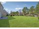 A large backyard with a well-maintained lawn and mature trees providing shade at 2311 Fall Creek Lndg, Loganville, GA 30052