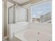 Bathroom featuring garden tub, glass shower, and bright natural light at 2311 Fall Creek Lndg, Loganville, GA 30052