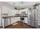 Well-lit kitchen with stainless steel appliances, ample counter space, and dark hardwood floors at 2311 Fall Creek Lndg, Loganville, GA 30052