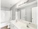 Bright bathroom featuring a double sink vanity, a large mirror, and a tub/shower with white tile at 2740 Barimore Pl, Dacula, GA 30019
