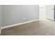 Neutral bedroom featuring gray walls, plush carpeting, and a white door, offering a cozy and comfortable space at 2740 Barimore Pl, Dacula, GA 30019