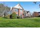 Beautiful two-story brick home with lush green lawn and mature trees at 2740 Barimore Pl, Dacula, GA 30019