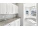 Bright kitchen featuring granite countertops and white cabinets with an open archway to the living room at 2740 Barimore Pl, Dacula, GA 30019