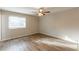 Bedroom features laminate flooring, a ceiling fan, and ample natural light from the window at 6939 Hickory Log Rd, Austell, GA 30168