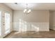 Bright dining area featuring French doors, stylish lighting fixture, wainscotting, and new flooring at 6939 Hickory Log Rd, Austell, GA 30168