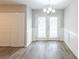 Dining area featuring french doors to yard, closet, chandelier, and new flooring at 6939 Hickory Log Rd, Austell, GA 30168