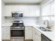 Renovated kitchen features white cabinets, stainless appliances, and updated countertops at 6939 Hickory Log Rd, Austell, GA 30168