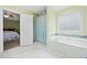 Bathroom featuring tiled tub, glass shower and doorway to bedroom at 2517 N Hightower Trl, Conyers, GA 30012