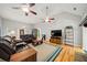 Spacious living room with vaulted ceiling, ceiling fans, hardwood floors, and comfortable leather furniture at 2517 N Hightower Trl, Conyers, GA 30012