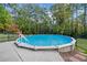 Enjoy this above-ground pool, encased by a black metal fence and surrounded by mature trees at 2517 N Hightower Trl, Conyers, GA 30012