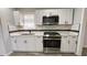 Modern kitchen featuring stainless steel appliances, granite countertops, and white cabinets at 624 S Grand Nw Ave, Atlanta, GA 30318