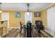 A well lit dining room is shown, featuring modern table and chairs, hardwood style flooring, and yellow walls at 660 Simmons St, Atlanta, GA 30318