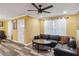 A sunlit living area has stylish floors, a sectional sofa, bright yellow walls, and a modern ceiling fan at 660 Simmons St, Atlanta, GA 30318
