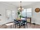 Cozy dining area featuring a modern chandelier, a round table, and natural light from surrounding windows and doors at 90 Citrine Way, Acworth, GA 30101