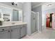 Well-lit bathroom featuring a glass shower, tile floors, and neutral-toned cabinetry at 3040 Peachtree Nw Rd # 1509, Atlanta, GA 30305