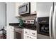 Close-up of kitchen appliances with stainless steel microwave, range, and a refrigerator with water dispenser at 3040 Peachtree Nw Rd # 1509, Atlanta, GA 30305