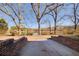 Brick pathway leading to scenic lake view framed by mature trees, ideal for relaxation and enjoying nature at 5010 Highway 20 Ne, Conyers, GA 30012