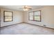 A spacious bedroom with carpeted floor and plenty of natural light from the large windows at 5010 Highway 20 Ne, Conyers, GA 30012