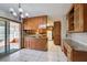 Traditional kitchen featuring wood cabinets, a tile backsplash, and a breakfast bar leading to a bright sunroom at 5010 Highway 20 Ne, Conyers, GA 30012