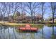 Lake view with a red dock and reflections in the water, surrounded by trees and landscaping at 5010 Highway 20 Ne, Conyers, GA 30012