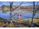 Scenic lake view featuring a vibrant red dock framed by bare trees, reflecting a peaceful and serene setting at 5010 Highway 20 Ne, Conyers, GA 30012