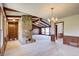 Large living room featuring a stone fireplace, carpet, and wood paneled walls at 5010 Highway 20 Ne, Conyers, GA 30012