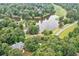 An aerial shot shows a lush, wooded neighborhood with a house near a pond and a golf course, perfect for recreation at 5053 Chapel Xing, Douglasville, GA 30135