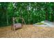 A peaceful backyard featuring a swing, mature trees, and lush landscaping at 5053 Chapel Xing, Douglasville, GA 30135