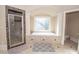 Well lit bathroom featuring a large tub with a decorative window and a glass enclosed shower at 5053 Chapel Xing, Douglasville, GA 30135