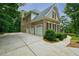 Spacious three-car garage with an expansive driveway, set against a backdrop of lush greenery at 5053 Chapel Xing, Douglasville, GA 30135