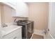 Well-equipped laundry room with washer, dryer, sink and storage at 5053 Chapel Xing, Douglasville, GA 30135