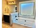 Bright bathroom featuring a soaking tub with a window and a vanity with dark cabinets at 611 Winners Cir, Locust Grove, GA 30248