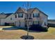 Two-story home featuring a well-maintained lawn, tree, and driveway with an attached two-car garage at 611 Winners Cir, Locust Grove, GA 30248