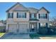 Charming two-story home featuring a two-car garage, well-maintained lawn, and inviting front entrance at 611 Winners Cir, Locust Grove, GA 30248