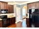 Well-equipped kitchen featuring dark cabinets, granite countertops, and stainless steel appliances at 611 Winners Cir, Locust Grove, GA 30248